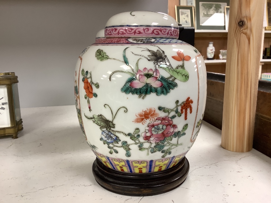 A pair of Chinese famille rose jars and covers, late 19/early 20th century, 15.5cm, on hardwood stands